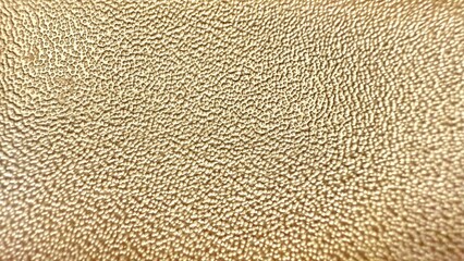 shimmering golden pebble textured surface with metallic glow perfect for elegant background or...