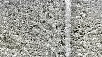 rough concrete surface with weathered white line detail for urban grunge background or abstract texture design