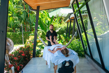 Therapist giving foot massage near pool