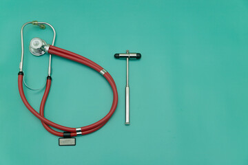 red stethoscope and medical hammer on green Background, Space for Text, Space for Logo
