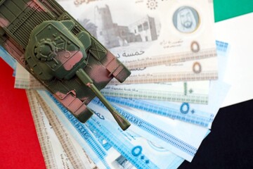 United Arab Emirates dirham currency money bills and toy tank on flag close up. The concept of army...