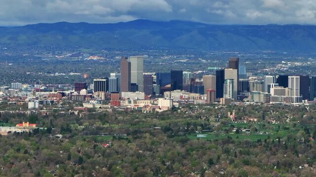 Downtown Denver skyscraper front range foothills landscape view aerial drone Colorado Northfield Stapleton Central Park spring morning rain clouds sunny cityscape Capitol building backwards pan up