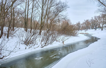 Winding Winter River in a Snowy Forest