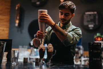 Bartender skillfully adds whipped cream to cocktails in a dimly lit, modern bar setting. The image showcases creativity, skill, and the professional art of cocktail preparation.