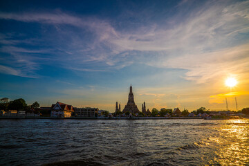 Fototapeta premium Wat arun ancient pagoda building buddhist temple of dawn sunset with travel boat Chao phraya river