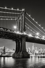 New York City black and white night view of the Manhattan Bridge from DUMBO. Illuminated Lower...