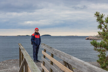 Young man hiking in Finnish nature reserve. Emphasizes eco-tourism, sustainable outdoor activity, and connection with pristine northern wilderness