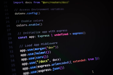 Close-up of JavaScript backend code showing Express app initialization with middleware configuration including CORS, Helmet, Morgan, and JSON parsing.