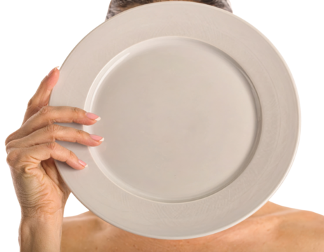 A person holds a large, plain white plate in front of their face against a dark background, creating a striking visual contrast and sense of mystery.
