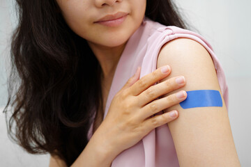 HPV, Human papilloma virus, Asian young woman receiving vaccine with blue bandage.