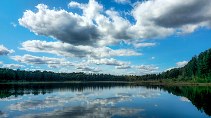 Serene lake reflecting a cloudy sky.