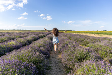 Young girl walking through a lavender field