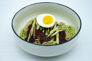 흰색 그릇에 담긴 비빔냉면과 오이 계란 