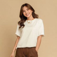 An Asian woman in a white t-shirt and shorts smiles warmly against a beige background, reflecting an easy summer style and casual comfort.