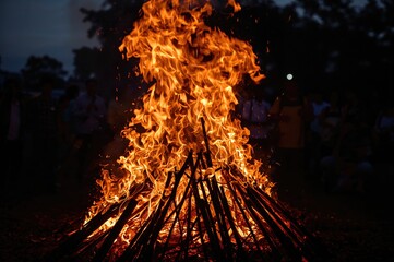 Blazing flames and fiery sparks emitted from a ceremonial pyre during a cultural celebration