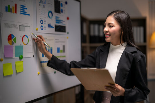 woman is standing in front of a white board with a presentation on it