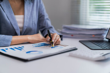 woman is sitting at a desk with a laptop and a calculator