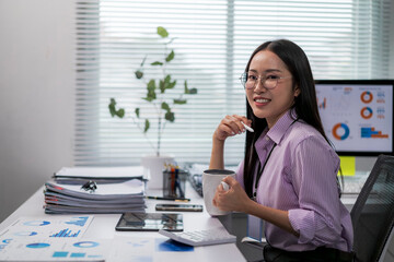 woman is sitting at a desk with a cup of coffee in front of her