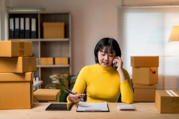 woman in a yellow shirt is talking on her cell phone while sitting at a desk w