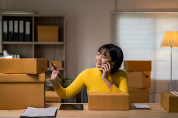 woman in a yellow shirt is talking on her cell phone while sitting at a desk w
