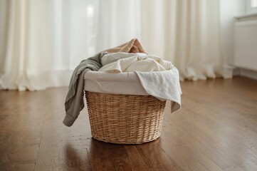 Laundry basket filled to the brim on wooden flooring inside a house
