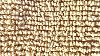 close up beige looped carpet fiber texture with soft woven detail under warm light ideal for background or surface design