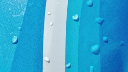 close up of blue and white waterproof fabric with water droplets forming on surface ideal for...