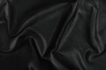 Fototapeta premium Synthetic black leather featuring waves and creases on a PVC foundation