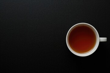 Dark backdrop featuring a tea cup and area for text