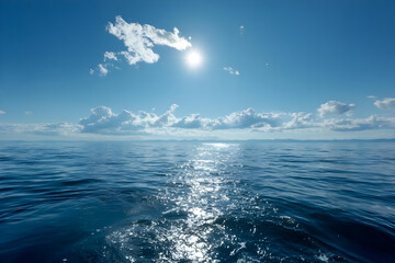 Fototapeta premium A tranquil view of the open ocean under a bright blue sky, showcasing shimmering water reflections and fluffy white clouds.
