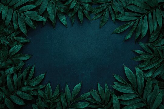 Neon blue foliage arrangement with blank area for text. Nighttime summer theme with vibrant green leaves. Flat composition showcasing natural elements.