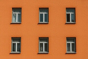 Obraz premium Exterior wall featuring four windows under bright sunlight