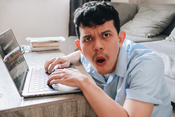 Surprised Man Working on Laptop in a Cozy Indoor Setting with a Modern Vibe