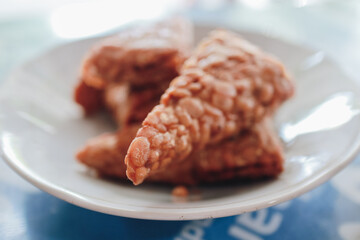 Deliciously Crunchy Fried Tempeh Triangles Served on a Simple White Plate With a Natural Background