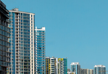 Modern urban skyline with tall apartment and office towers under clear blue sky. Highrise glass and