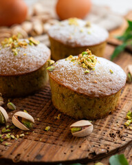 Pistachio muffins on a wooden surface.