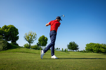 Golfer performing swing on sunny golf course