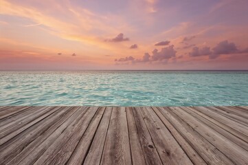 Fototapeta premium A wooden deck extends into the retreating ocean waters beneath a colorful sunset sky.