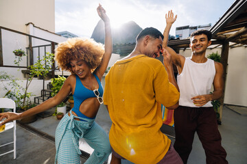 Group of three friends dancing outside on a sunny day