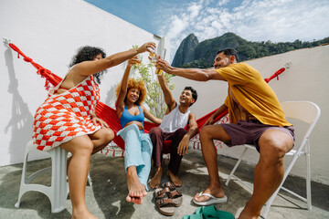 Friends toasting on a sunny rooftop near Corcovado in Rio de Janeiro