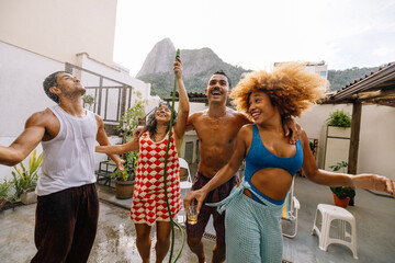 Rooftop hose bath fun as Brazilian friends cool off in Rio