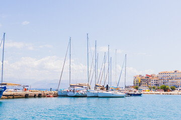Picturesque scene of sailboats moored in a tranquil harbor, framed by vibrant coastal architecture...