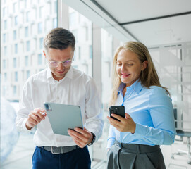 Colleagues engaged in a collaborative discussion with digital devices in a modern office