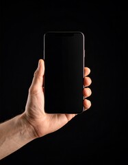 Hand holding a dark smartphone against a black background