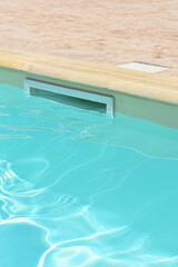 Relaxing in swimming pool. Swimming pool blue water reflecting the sun rippled details. Patterns of...