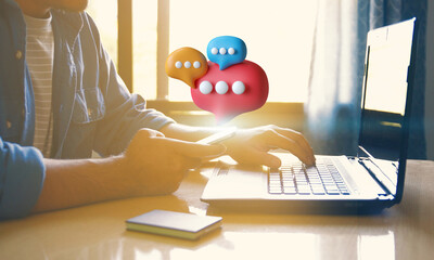 Man Typing on Laptop with Chat Bubbles