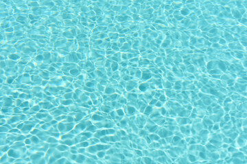Relaxing in swimming pool. Swimming pool blue water reflecting the sun rippled details. Patterns of movement of water in the pool. Summer background. Water movement background. Banner with copy space.