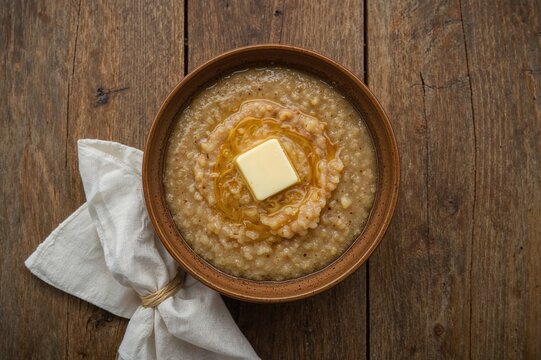 Tasty buckwheat cereal with butter served on a rustic wooden surface, overhead perspective. Space available for text