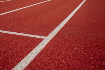 Detailed view of a crimson running lane marked with white stripes