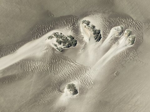 Small sand heaps form around the sparse vegetation in the Namib Desert. Aerial view. Drone shot. Skeleton Coast National Park, Namibia